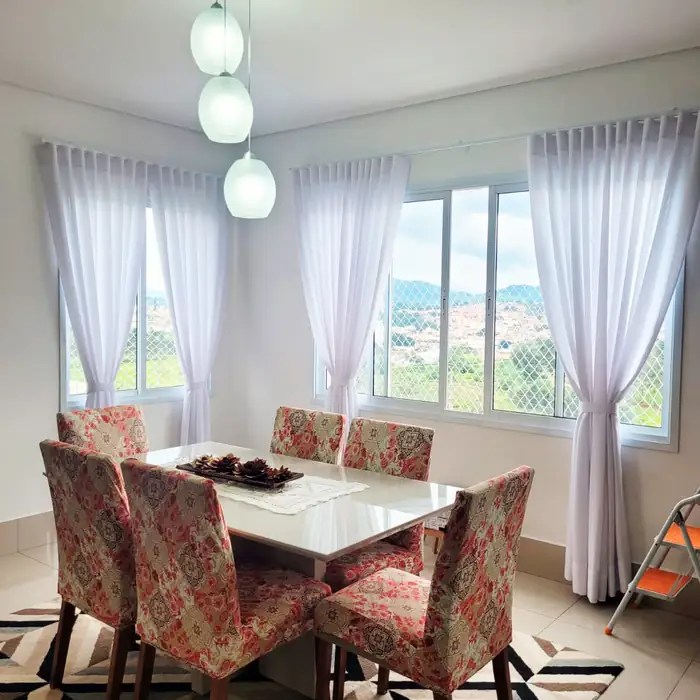 Cortinas sheer contemporâneas em sala de jantar com vista da serra — tendência de tecidos leves e naturais