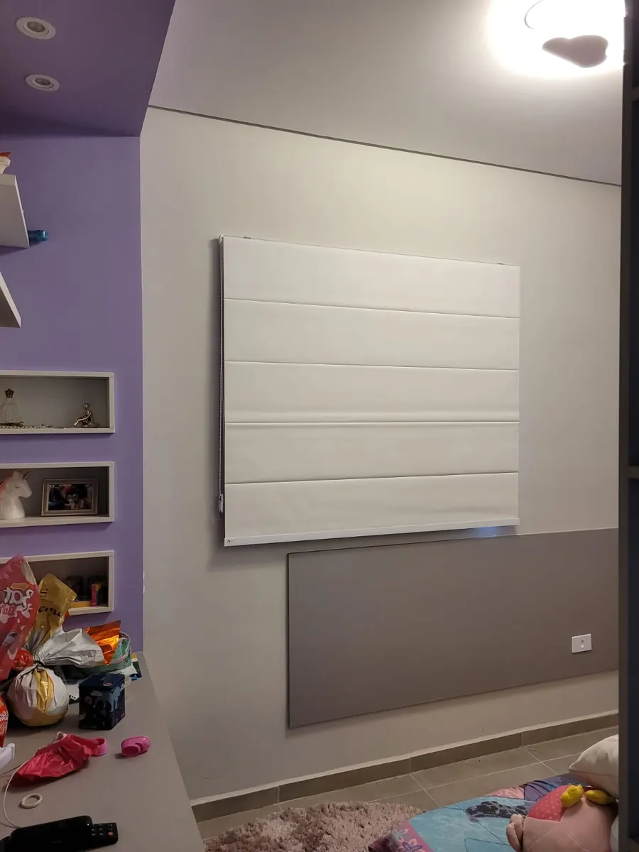 Persiana romana branca em quarto infantil com parede roxa e prateleiras decorativas, confeccionada pela Neusa em Atibaia